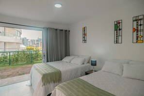 A bedroom with two beds, a balcony, and city views. - Apto moderno en Serena con balcon  (Cartagena)