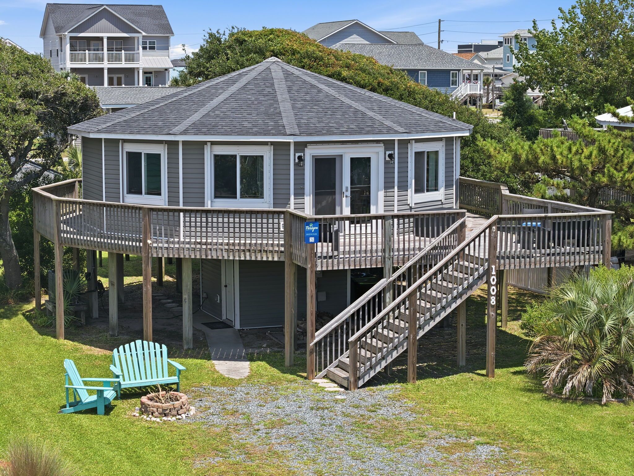 A two-story house with a deck, a staircase, and a covered porch area.