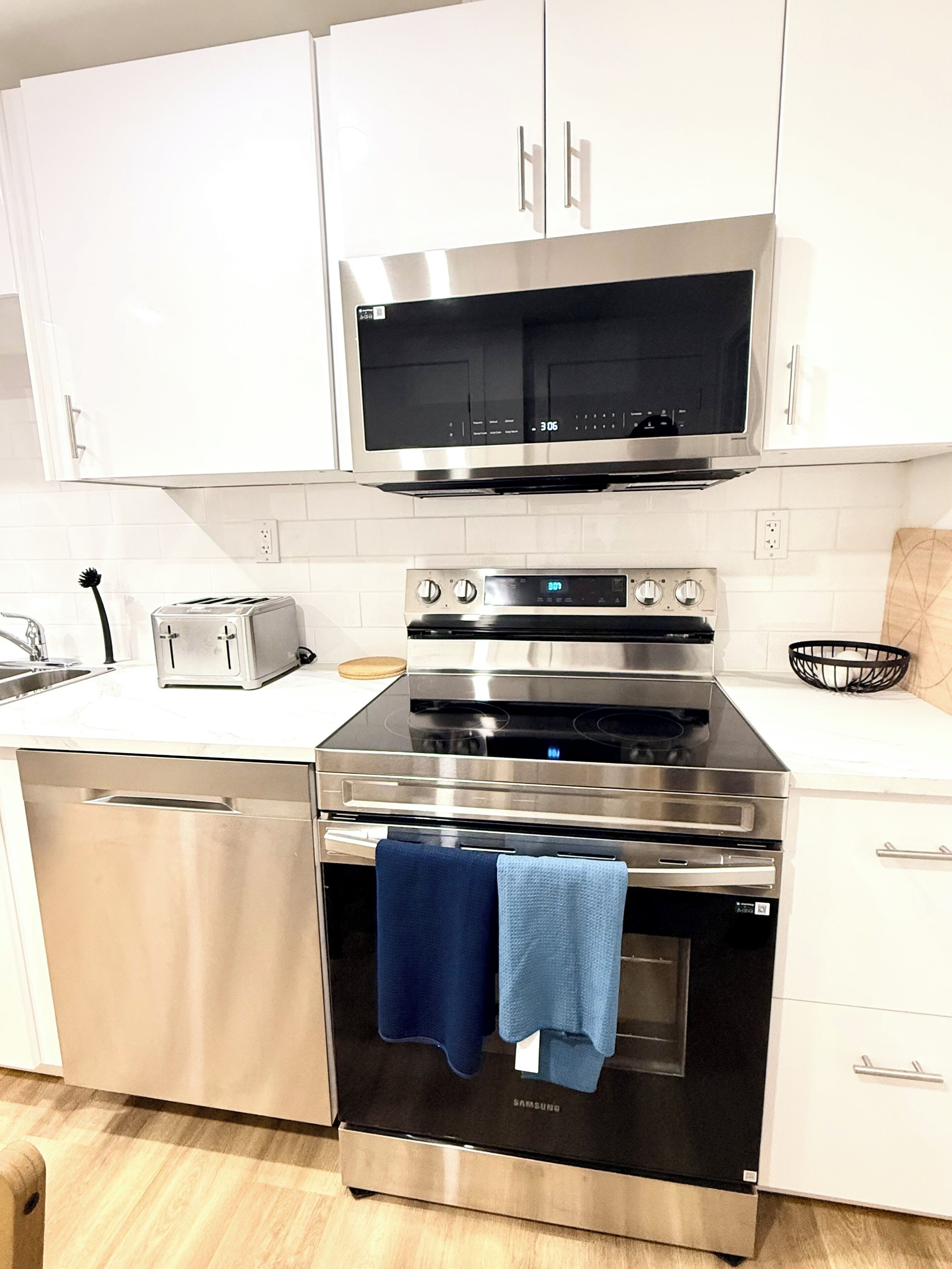 A modern kitchen with stainless steel appliances, including a microwave, toaster, and oven.
