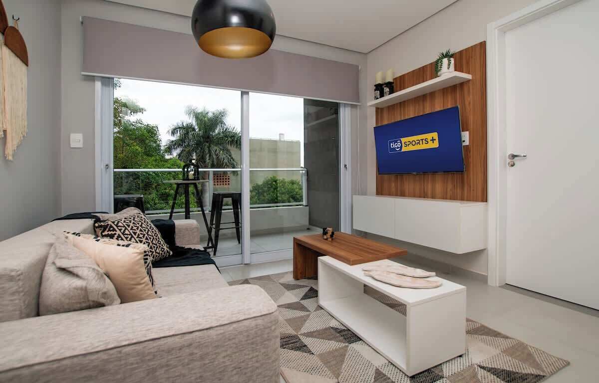 A modern living room with a sofa, coffee table, and TV mounted on a wall.