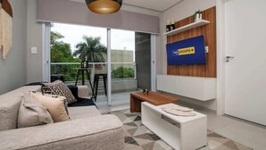 Una sala de estar moderna con sofá, mesa de centro y televisor montado en la pared.
