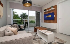 Ein modernes Wohnzimmer mit einer Couch, einem Couchtisch und einem an der Wand montierten Fernseher.