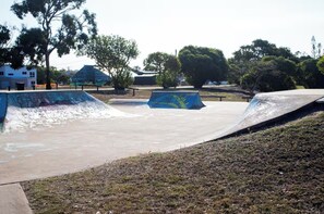 Un parc à rollers avec des rampes et une zone herbeuse.