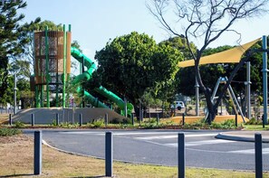 A playground with a green slide and climbing structures.