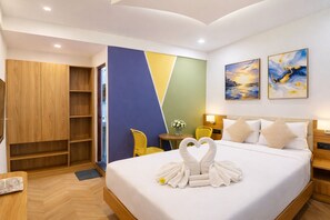 A hotel room with a bed, a wardrobe, a desk, a chair, and artwork on the walls. - Hotel Royal Orbit Near Dronacharya Metro (Gurgaon)