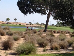 A golf course with a pond, trees, and a clear sky. - Adriatico Groundfloor Frontline Golf - 2 Bath - 3 Min Walk to Amenities (Sucina)