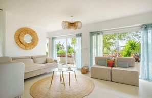 A modern living room with a sofa, a coffee table, and a large mirror. - Apartment Near the Beaches - Sleeps 6 - Théoule-sur-Mer (Théoule-sur-Mer)
