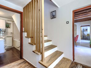 Eine Treppe mit Holzboden und Holzgeländer, die zu einer oberen Etage führt.