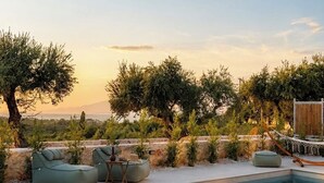 A pool with lounge chairs and a wooden deck. - Conte Maris II - Sea View Mediterranean Escape (Tragaki)