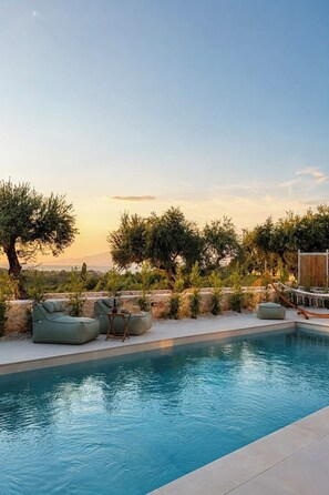 A pool with lounge chairs and a wooden deck. - Conte Maris II - Sea View Mediterranean Escape (Tragaki)