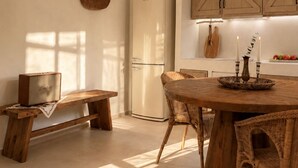 A modern kitchen with a central island, wooden cabinetry, and a built-in refrigerator. - Conte Maris II - Sea View Mediterranean Escape (Tragaki)