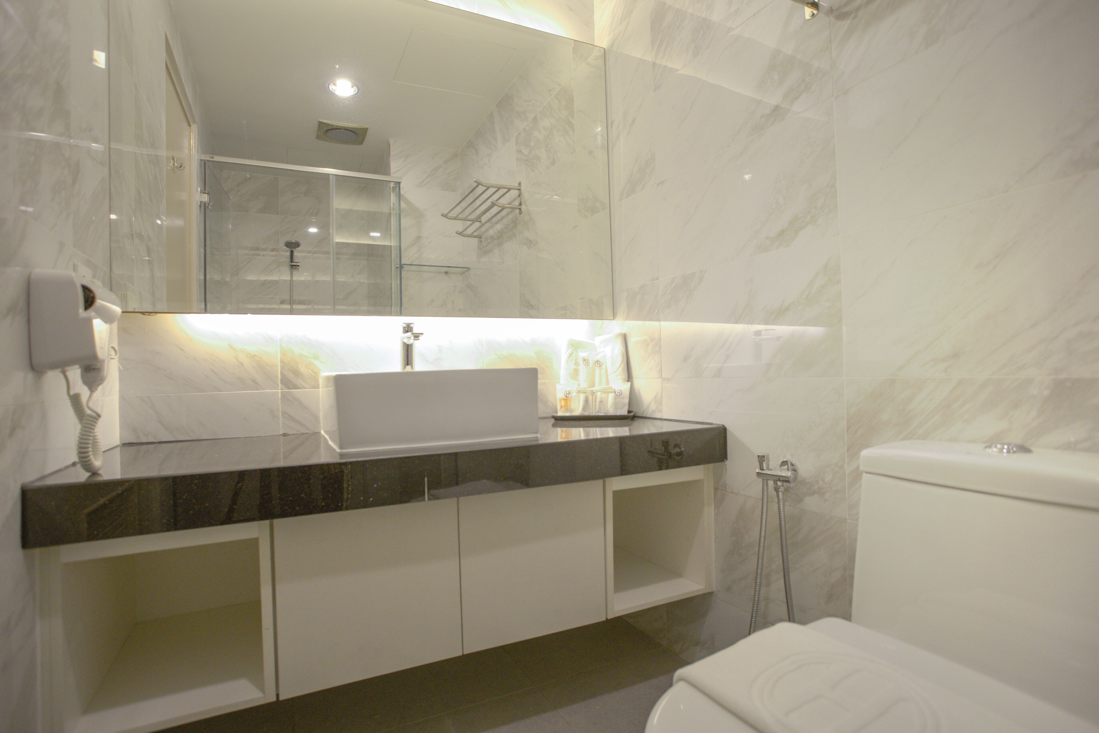 A modern bathroom with a white sink, a mirror, and a shower.
