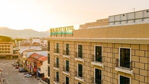 A hotel building with a sign reading 'The Host Hotel,' multiple windows, and a parking lot. - THE HOST HOTEL (Ipoh)
