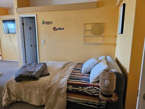 A bedroom with a bed, pillows, a bedside lamp, and a wall decoration. - The Spring Meadow House. (Willits)