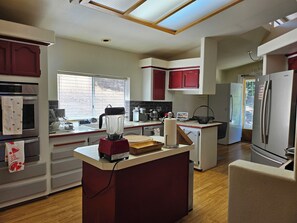 Una cocina moderna con una isla central, un refrigerador y un lavavajillas.