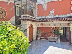 A courtyard with a tiled floor, a wooden door, and a potted plant. - Apartment Monte by Interhome (Umag)