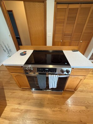 Eine Küche mit eingebautem Herd, Backofen und einer Holz Arbeitsplatte.
