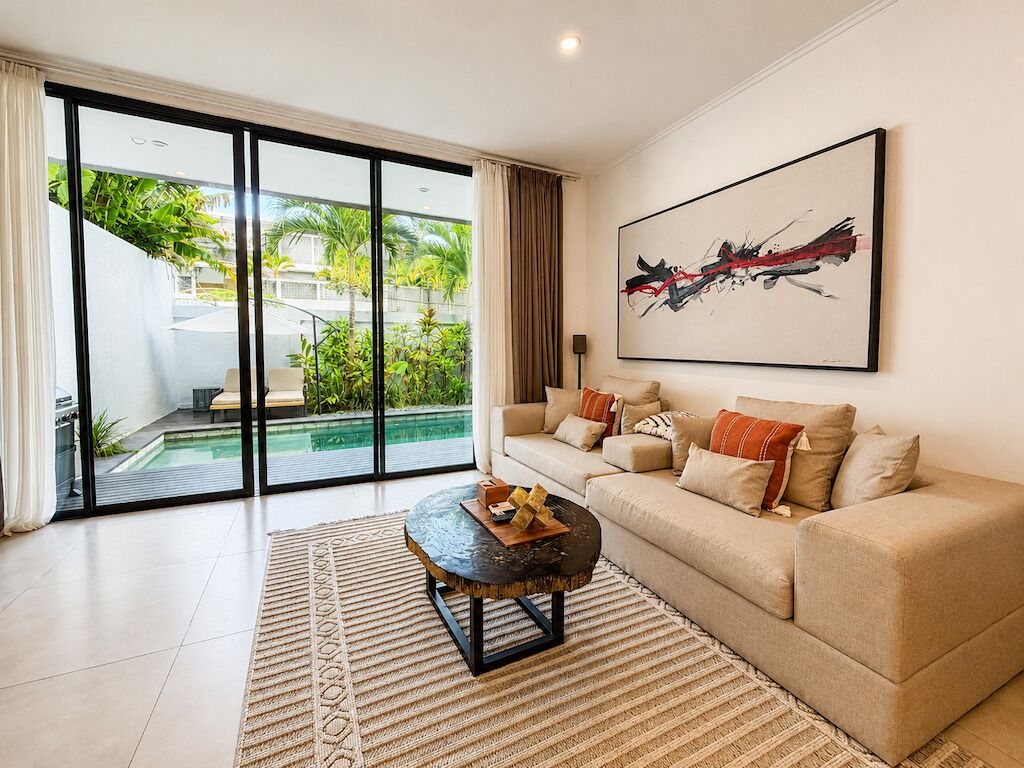 A modern living room with a sofa, a coffee table, and a large abstract painting.