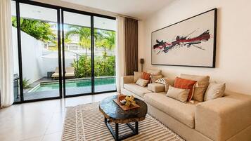 A modern living room with a sofa, a coffee table, and a large abstract painting.