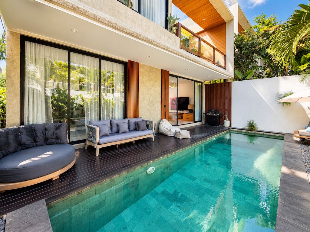A modern house with a swimming pool, a sofa, and a TV.