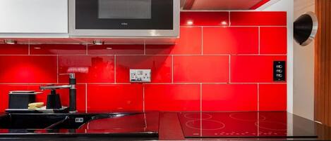 Une cuisine équipée d’un four encastré, d’une plaque de cuisson et d’un four à micro-ondes.
