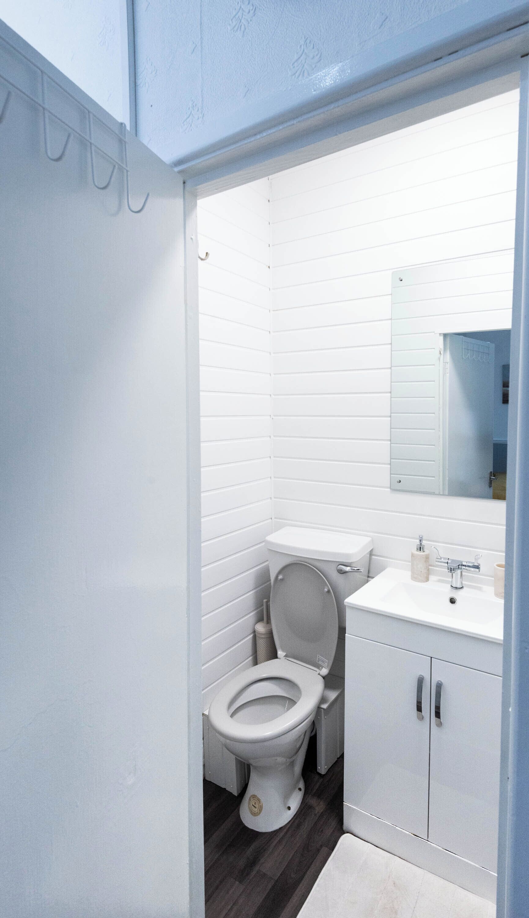 A modern bathroom with a toilet, sink, and mirror.