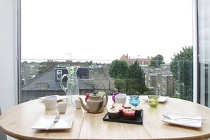 Una mesa con vista a un paisaje urbano a través de una ventana.