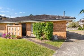 A residential house with a tiled roof, brick walls, a small front yard, and a clear sky. - Peaceful 1-Bed Apartment in Kedron with Parking (Kedron)