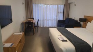 A hotel room with a bed, a desk, a chair, a TV, and a sofa. - Wanaka Club Wyndham Resort.  5th-17th September 12 nights Studio King Sleeps 3. (Wānaka)
