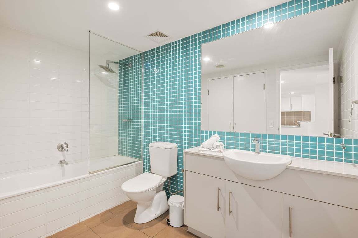 Un baño con bañera, inodoro, lavabo y espejo.