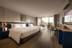 Een hotelkamer met een groot bed, een bureau en een balkon met uitzicht.