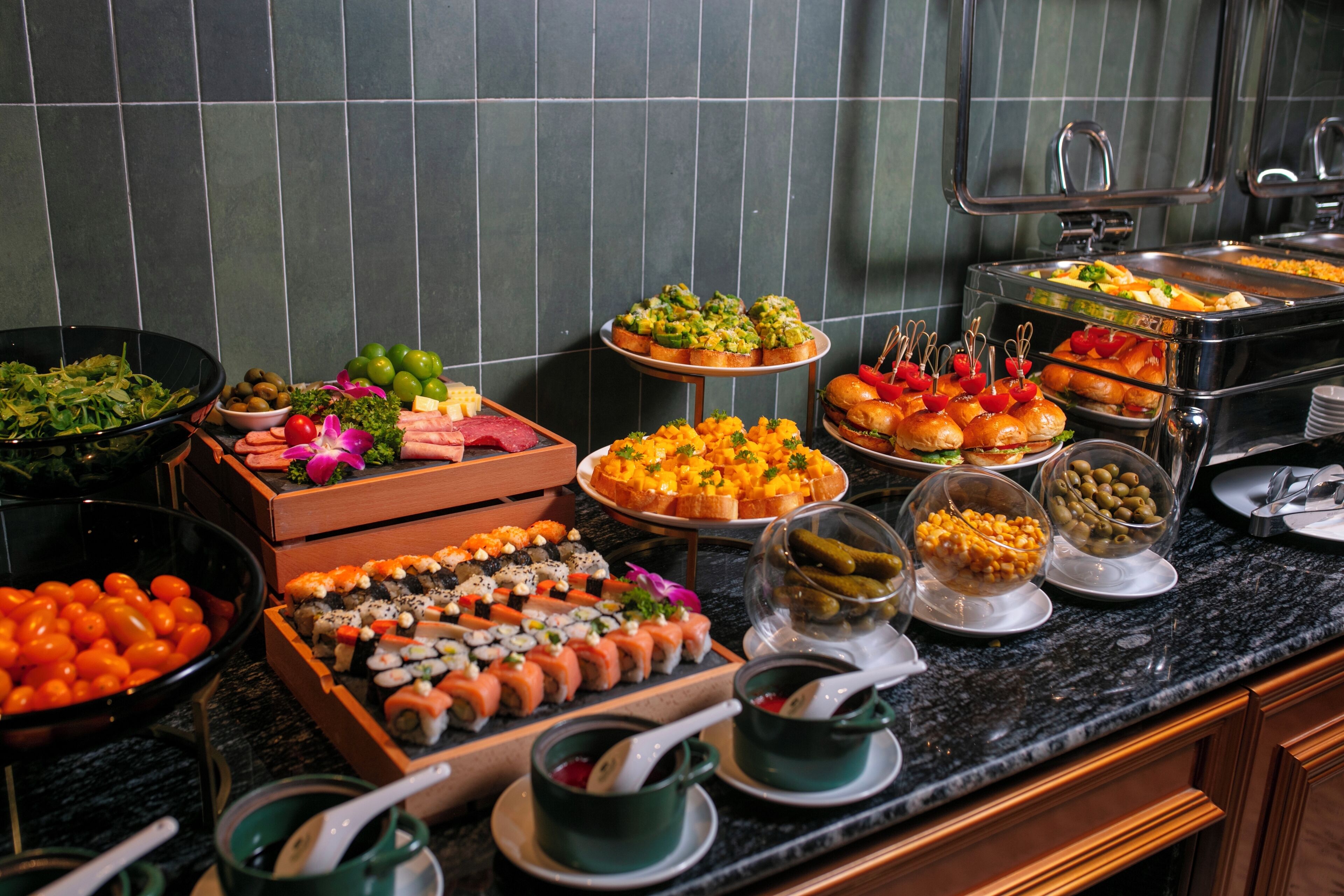 A buffet with various food options including sushi, salads, and sandwiches.