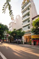 Un hôtel à plusieurs étages, doté d’une façade moderne, de balcons et d’un magasin situé au rez-de-chaussée.