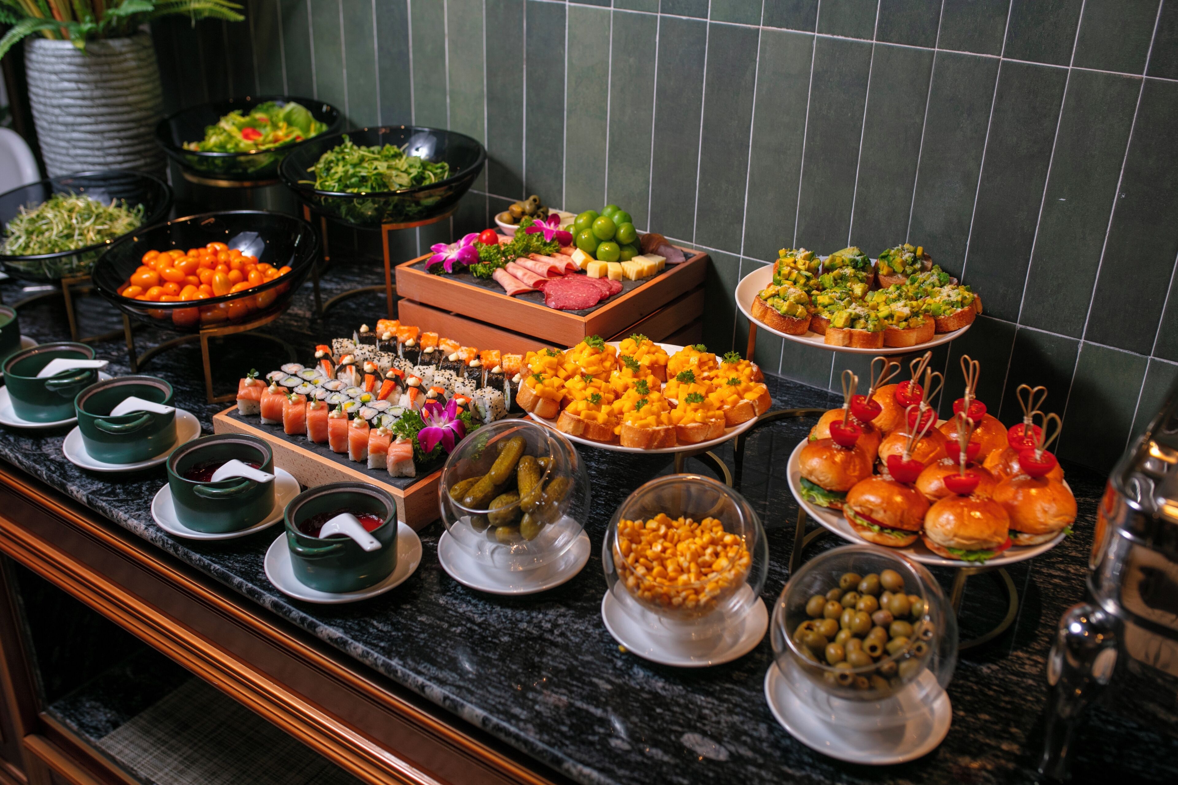 A buffet with various food items including sushi, cheese, and bread.