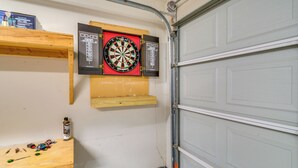 Een garage met een dartbord, gereedschapskasten en een sensorbox.