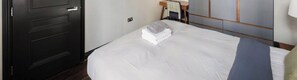 A hotel room with a bed, a desk, and a wardrobe. - Prime 2 bedrooms flat in Knightsbridge- Harrods view / portable air conditioning (London)