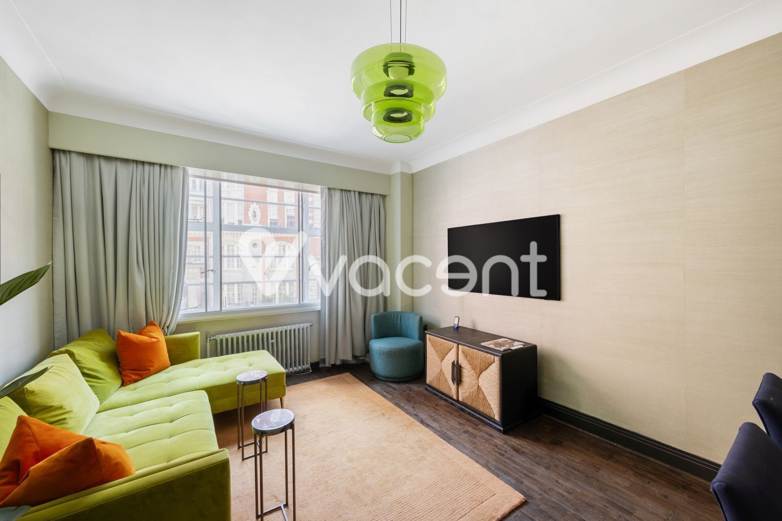 Ein modernes Wohnzimmer mit einer Couch, einem Sessel, einem kleinen Tisch und einem Schrank.