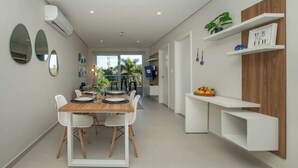 Une cuisine moderne avec une table à manger, des chaises et des étagères intégrées.