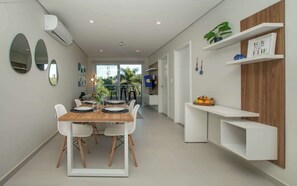 A modern kitchen with a dining table, chairs, and built-in shelves. - Corporate Stays First Living - 206 (Asunción)