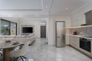 Eine moderne Küche mit Einbauofen, Kühlschrank und einem Essbereich mit Tisch und Stühlen.
