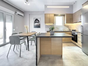 Una cucina moderna con isola centrale, elettrodomestici integrati e zona pranzo con sedie e tavolo.