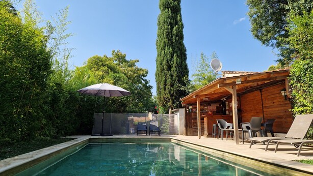 Ein rechteckiger Pool mit Holzterrasse und Liegestühlen.