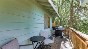 A covered outdoor deck with a table and chairs, a grill, and a view of trees. - Deck & Mtn Views! Woodsy Haven in Running Springs (Running Springs)