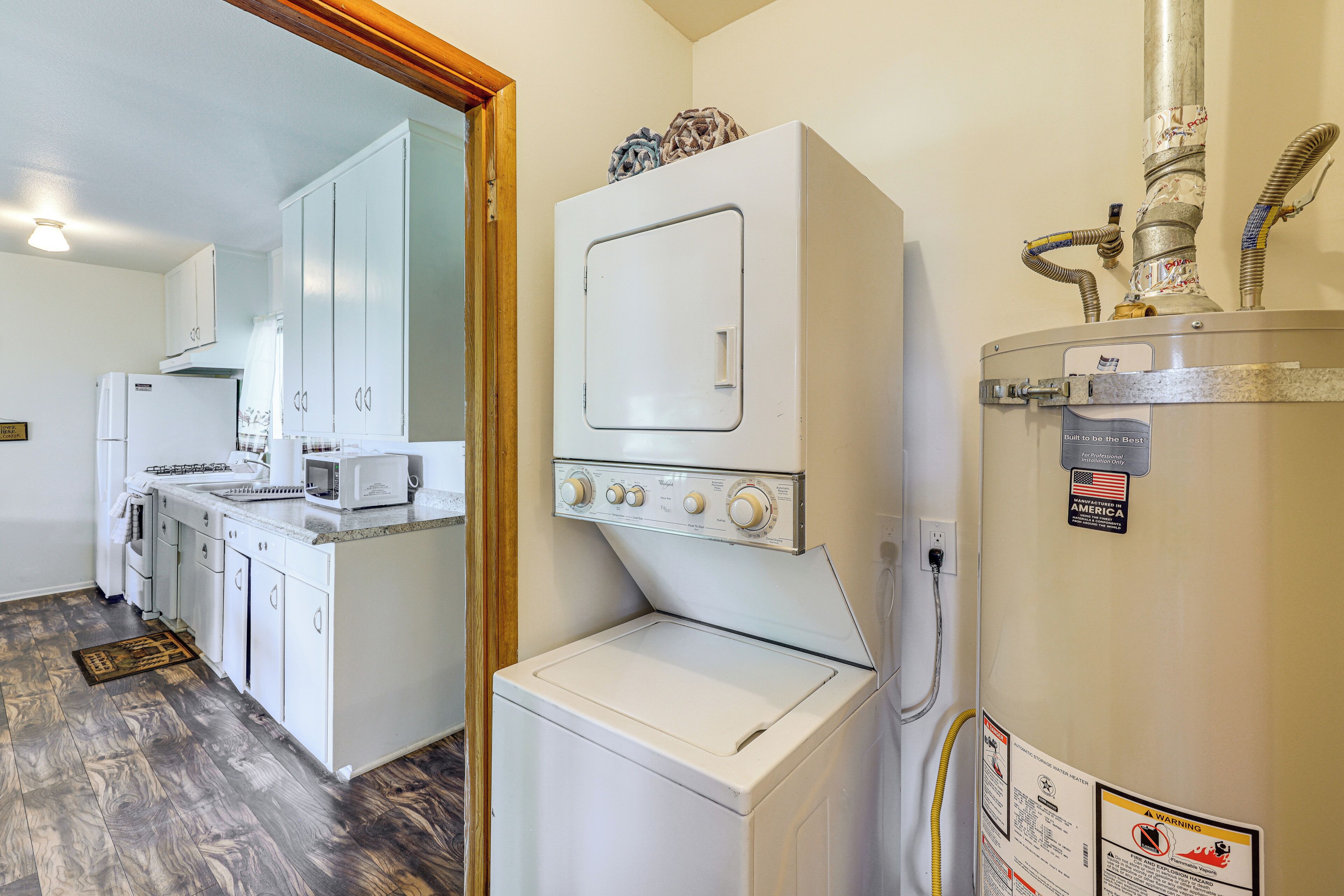 A compact kitchen with a built-in washer and dryer, a microwave, and a stove.