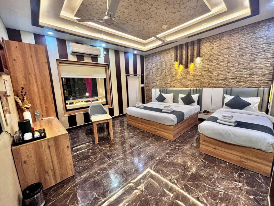 A modern hotel room with a marble floor, two beds, a desk, and a vanity with a mirror.