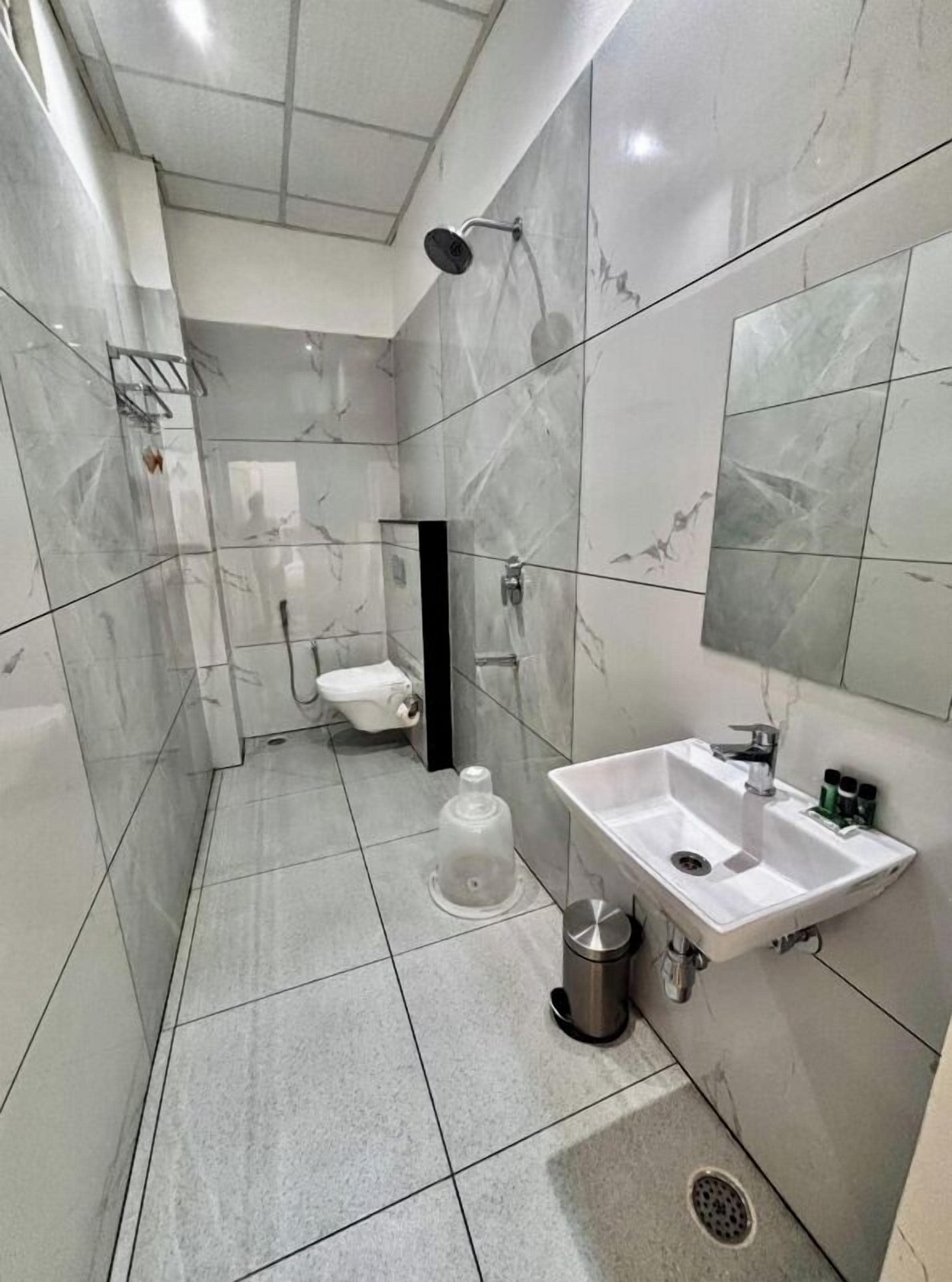 A bathroom with a toilet, sink, and shower.