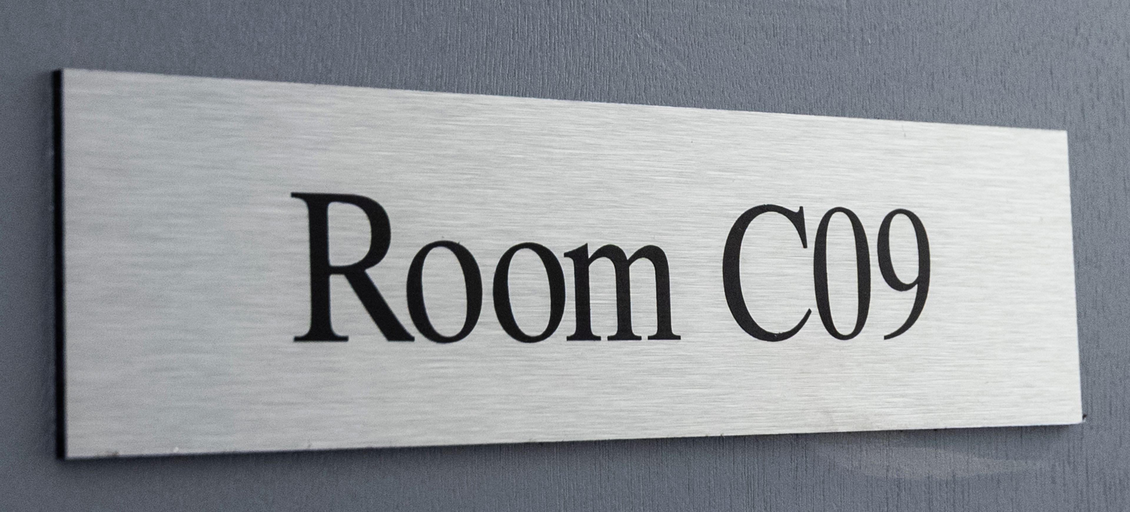 A metal sign with 'Room C09' indicating a specific room number.