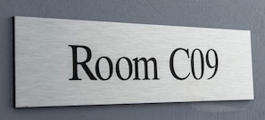 Un senyal metàl·lic amb la inscripció 'Room C09', que indica un número de habitació concret.