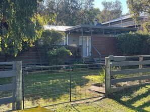 A residential property with a fenced yard, a wooden gate, and a house with a number '51' on the door.