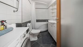 A compact bathroom with a toilet, sink, and bathtub.